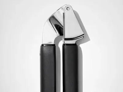 Stainless steel garlic press with ergonomic handles for healthy family meal prep, postpartum cooking, freezer meal preparation, and quick weeknight dinners.