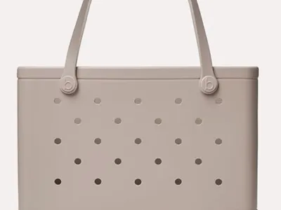 Beige waterproof beach tote bag with durable handles, perfect for carrying towels, sunscreen, snacks, toys, and family beach essentials.