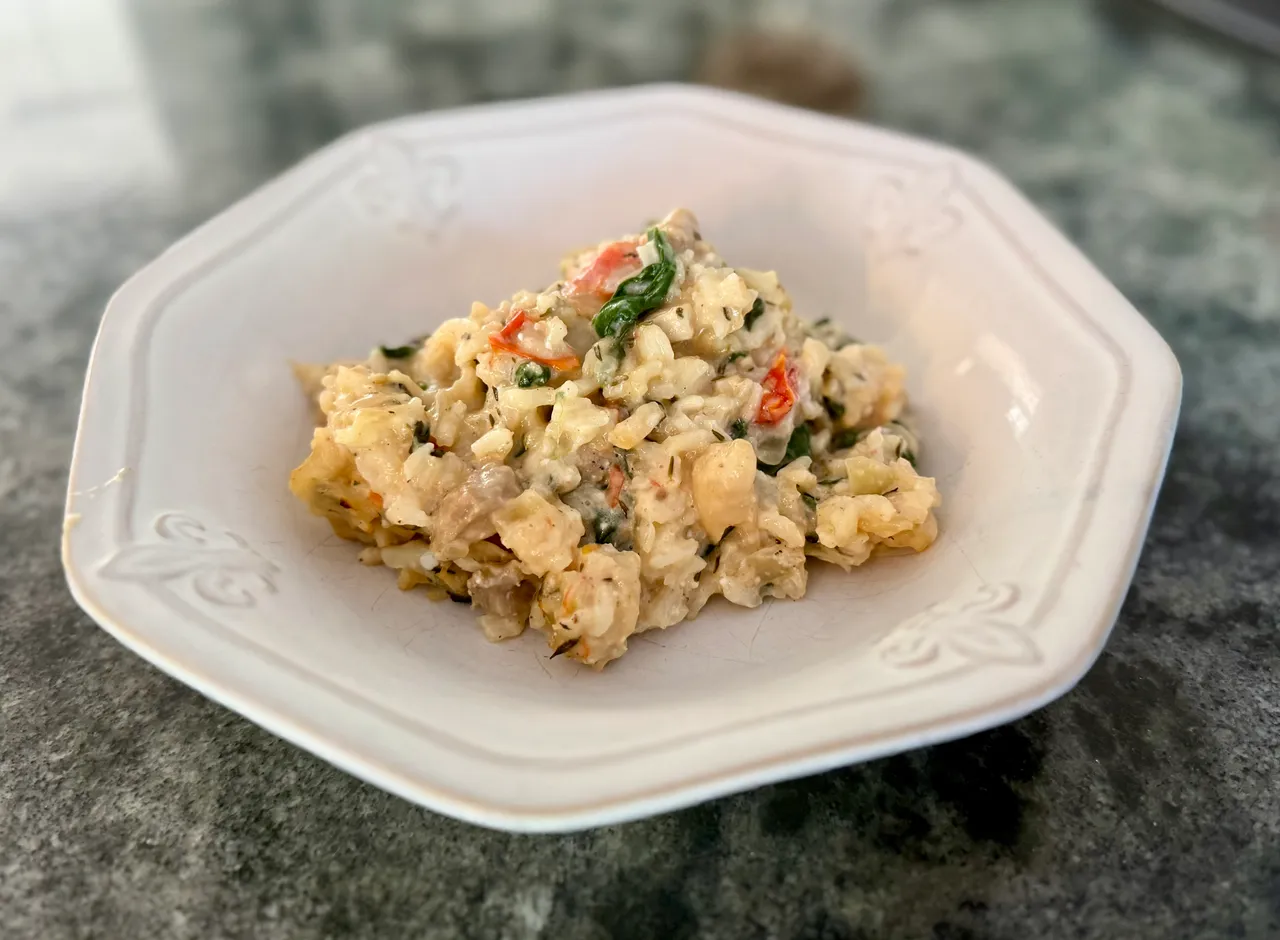 Creamy chicken, rice, spinach, and cottage cheese casserole served in a white bowl, a high-protein freezer meal perfect for postpartum recovery, meal prep, and healthy family dinners.