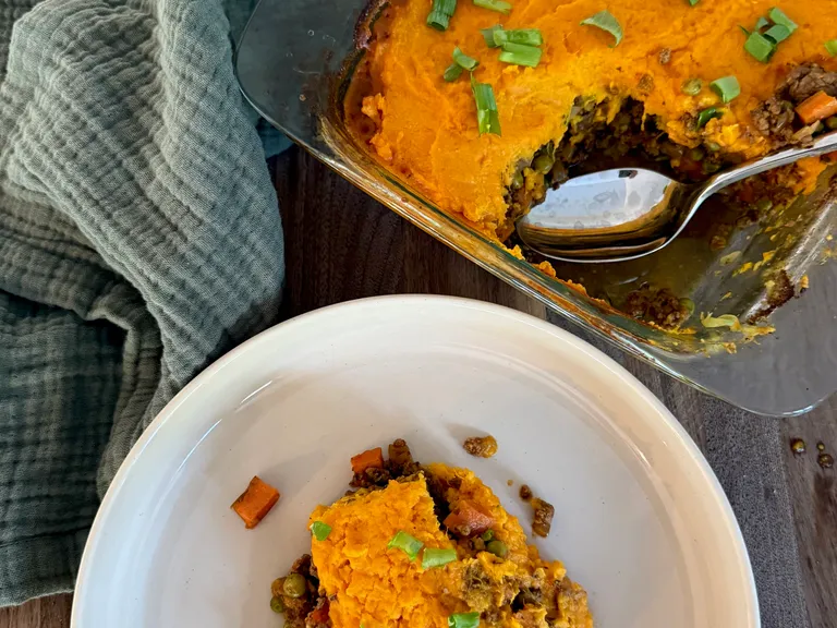 Homemade sweet potato cottage pie with seasoned ground beef, vegetables, and creamy mashed sweet potato topping, perfect for postpartum freezer meal prep and healthy family dinners.