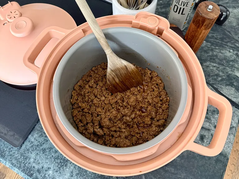 Lean ground beef browning in Our Place DreamCooker as the first step in making healthy beef and sweet potato chili.